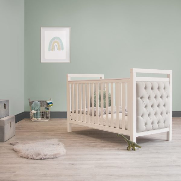 Blue and grey baby bedroom Nursery kids room. Cot and bed interiors with rainbow picture and faux fur rug.
Blue toy chests and blankets